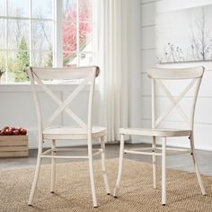 two white chairs sitting on top of a rug