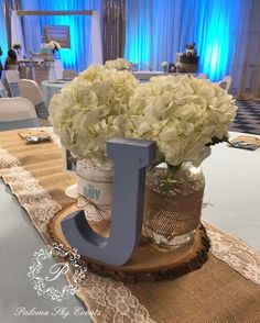 the centerpiece is made out of wood and has flowers in it, as well as an initial