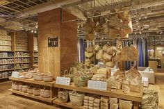 baskets and other items are on display in a store with wooden shelves, hanging from the ceiling