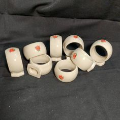 a group of white vases sitting on top of a black cloth