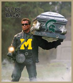 a man carrying a football helmet on top of his head with the michigan m logo