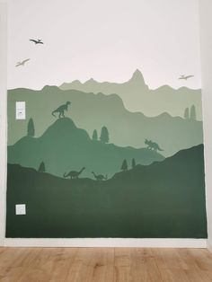 a wall with dinosaurs and birds painted on it in front of a mountain range mural