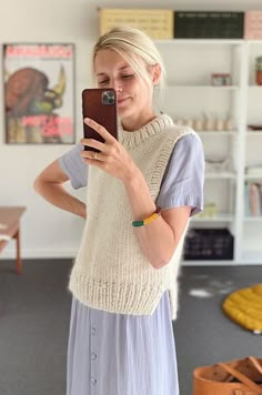 a woman taking a selfie with her cell phone in a room full of books