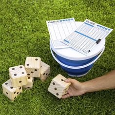 a person is playing with wooden dices on the grass