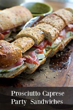 two sub sandwiches cut in half on a cutting board