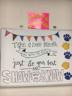 a white board with writing on it and some dogs paw prints hanging from the wall