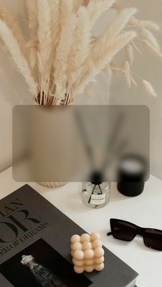 a white table topped with sunglasses and a book