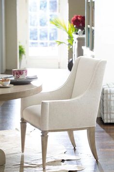 a white chair sitting next to a table in a living room