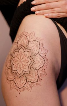 a close up of a woman's thigh with a flower tattoo on the side