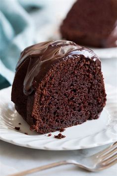 a piece of chocolate cake sitting on top of a white plate with a bite taken out of it