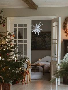 a living room with a christmas tree in the corner and other decorations on the wall