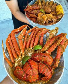 two buckets filled with crabs and corn on the cob