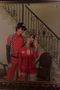 a man and woman dressed in racing outfits taking a selfie with a cell phone