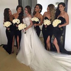 a group of women standing next to each other in front of a mirror holding bouquets