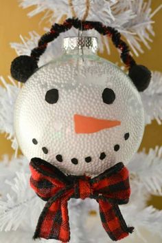 a snowman ornament hanging from a christmas tree