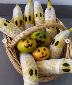 a basket filled with bananas and oranges decorated like faces