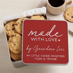 a cookie tin filled with cookies next to a cup of coffee