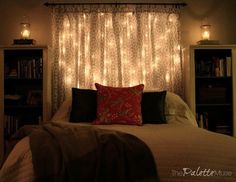 a bedroom with lights on the headboard and bed in front of a book shelf