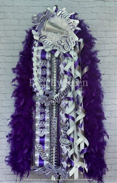 purple and white feathered garter hanging on a brick wall