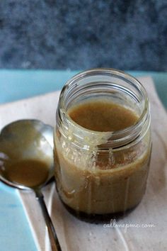 a spoon sitting on top of a napkin next to a jar filled with brown liquid