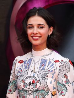 a woman in a white dress smiling at the camera