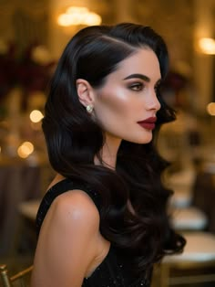 a woman with long black hair and red lipstick posing for a photo in a restaurant