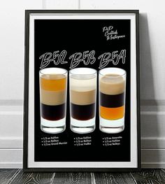 three shot glasses filled with different types of drinks in front of a black and white poster