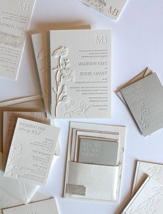 the wedding stationery is laid out on top of each other