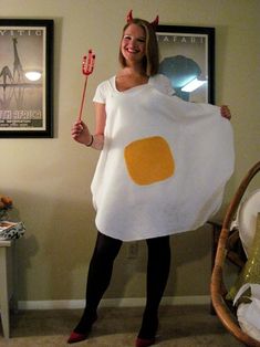 a woman dressed in an egg costume holding a toothbrush