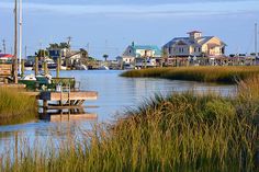 a body of water that has some boats in it and houses on the other side