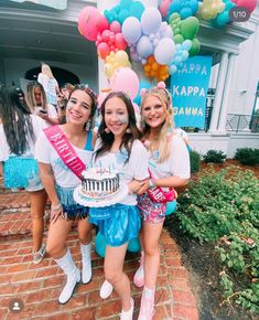 three girls are posing with a cake and balloons