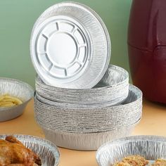 several tin foil containers filled with food on top of a table next to an air fryer