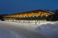 an empty ski slope covered in snow with lights on the roof and poles attached to it