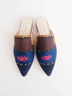 Crafted by artisans skilled in the great Turkish shoemaking tradition, our handmade ikat mules are crafted of genuine leather soles and only the finest natural cotton kilim, raw silk and silk velvet textiles available. As each of our stunning ikat mules are made by hand, no two pairs are exactly alike. Thus, each pair of these luxury mules is entirely unique -- just like you! Our luxury ikat mules are available in a wide array of colors and patterns, in both rounded and pointed toe-styles. We of Artisan Closed Toe Mules With Leather Sole, Bohemian Handmade Slip-on Mules, Handmade Artisan Mules For Summer, Handmade Bohemian Slip-on Mules, Artisan Handmade Slip-on Mules, Traditional Summer Mules With Pointed Toe, Handwoven Slip-on Mules, Artisan Brown Slip-on Mules, Traditional Handmade Flat Mules