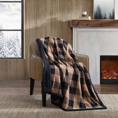 a chair with a blanket on it in front of a fireplace