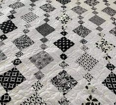 a black and white quilt on top of a bed