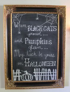 a chalkboard with writing on it in a gold frame hanging on the wall next to a light