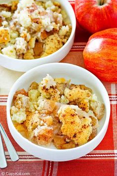 two white bowls filled with food next to an apple