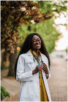 a woman with long hair wearing a lab coat and holding a cell phone in her hand