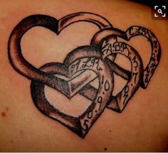 a couple of heart shaped tattoos on the back of a woman's shoulder