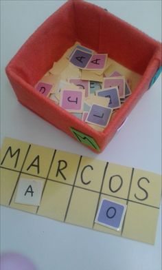 a red bowl filled with lots of magnets next to a yellow and purple box