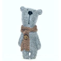 a gray teddy bear with a brown scarf around it's neck