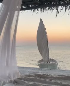 a sailboat on the water with a canopy over it's head at sunset