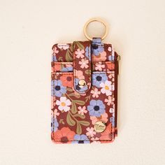 a flowered wallet with a gold keychain hanging from it's side