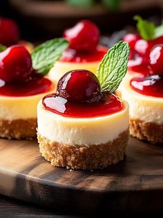 small cheesecakes with cherries and mint leaves on a cutting board, ready to be eaten