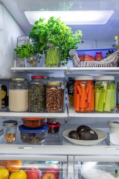 an open refrigerator filled with lots of different types of vegetables and fruit in it's shelves