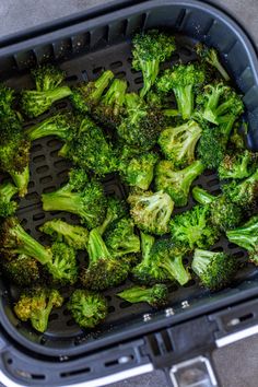 a plastic container filled with lots of green broccoli