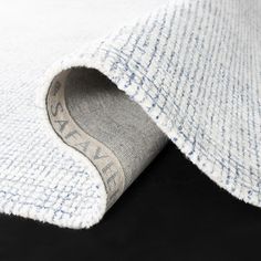 a close up view of the inside of a white and blue rug with a black background