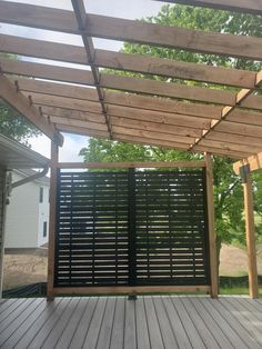 a wooden deck with black slatted screens on the top and bottom part of it