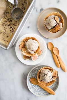 two plates with desserts on them sitting on a table next to utensils